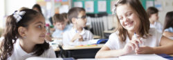 Two students giggle together while having a discussion