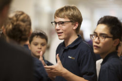 A young man gestures with his body language subconsciously while focusing on his communications to his peers