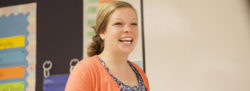 A teacher smiles to the class during instruction