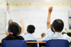 A student raises his hands in question