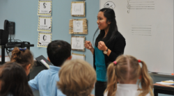 An instructor tenses her fists expressively with a disarming smile